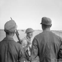 THE CAMPAIGN IN NORTH AFRICA 1940 - 1943 (E 18522) A British soldier gives a V-for-Victory sign to German prisoners captured at El Alamein, 26 October 1942. Copyright: © IWM. Original Source: http://www.iwm.org.uk/collections/item/object/205192925